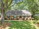 Charming brick home with a well-manicured lawn, mature trees, and neat shrubbery at 629 Wingrave Dr, Charlotte, NC 28270
