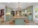 Spacious kitchen with island, green cabinets, brick backsplash, and stainless steel appliances at 629 Wingrave Dr, Charlotte, NC 28270