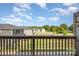 View from a balcony overlooking a grassy area with trees and neighboring homes at 7012 Bryce Ave, Charlotte, NC 28217