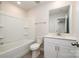 Clean, white bathroom features a tub, toilet, vanity with sink, and tiled floor at 7012 Bryce Ave, Charlotte, NC 28217