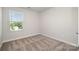 A standard carpeted bedroom with neutral walls and a window that provides natural light at 7012 Bryce Ave, Charlotte, NC 28217