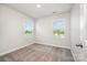 Bright bedroom featuring neutral walls, carpeted flooring, and natural light from two windows at 7012 Bryce Ave, Charlotte, NC 28217