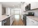 Bright kitchen with white cabinets, stainless steel appliances and granite countertops open to a spacious living area at 7012 Bryce Ave, Charlotte, NC 28217