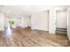 Open-concept living area with wood floors that seamlessly connect to kitchen, and stairway to the upper level at 7012 Bryce Ave, Charlotte, NC 28217