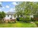 This backyard features mature trees, lush green grass and a charming well at 805 S Main St, Mount Holly, NC 28120