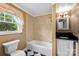 Bright bathroom with tile floors, tub, and a black countertop sink at 805 S Main St, Mount Holly, NC 28120