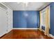This bedroom features built-in wardrobes, lovely blue walls and hardwood floors at 805 S Main St, Mount Holly, NC 28120