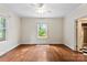 Well-lit bedroom with hardwood floors, ceiling fan, and window overlooking green outdoor space at 805 S Main St, Mount Holly, NC 28120
