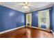 Cozy bedroom with hardwood floors and two large windows, showcasing a serene view of lush greenery at 805 S Main St, Mount Holly, NC 28120