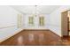 Elegant dining room with hardwood floors, natural light from shuttered windows, and a stylish chandelier at 805 S Main St, Mount Holly, NC 28120