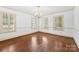 Bright dining room featuring hardwood floors, a classic chandelier, and shuttered windows offering ample natural light at 805 S Main St, Mount Holly, NC 28120