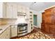 Updated kitchen featuring stainless steel oven, white cabinets, stainless steel range hood and decorative flooring at 805 S Main St, Mount Holly, NC 28120