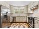 Well-lit kitchen with stainless steel appliances, white cabinetry, decorative backsplash, and uniquely patterned floors at 805 S Main St, Mount Holly, NC 28120