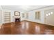 This living room features a lovely brick fireplace, beautiful hardwood floors and natural light at 805 S Main St, Mount Holly, NC 28120
