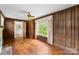 Living room featuring wood paneling, a ceiling fan, and hardwood floors at 805 S Main St, Mount Holly, NC 28120