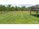 Expansive backyard with lush green grass, wooden fencing, and a rustic fire pit at 830 John Rainey Rd, Salisbury, NC 28147