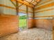 Spacious horse barn interior with an open doorway to a green pasture at 830 John Rainey Rd, Salisbury, NC 28147