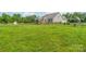 Vast, grassy parcel featuring a home and wooden fence, offering ample space for development and privacy at 830 John Rainey Rd, Salisbury, NC 28147