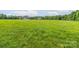 Expansive grassy horse pasture with fencing and a house in the distance at 830 John Rainey Rd, Salisbury, NC 28147