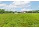 Large fenced horse pasture with a home in the distance at 830 John Rainey Rd, Salisbury, NC 28147