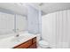 Bright bathroom with a white shower curtain, vanity, and soft blue walls at 833 Lemond Ln, Denver, NC 28037