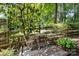 Secluded backyard sitting area with a wooden table, chairs, and a wooded backdrop at 8700 Fox Tail Ln, Huntersville, NC 28078