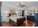 Cozy bedroom featuring wood floors, a queen bed, ceiling fan, and natural light at 8700 Fox Tail Ln, Huntersville, NC 28078