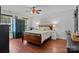 Cozy bedroom featuring wood floors, a queen bed, ceiling fan, and natural light at 8700 Fox Tail Ln, Huntersville, NC 28078