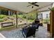 Inviting covered patio with a stone fireplace, seating, and a lush garden view at 8700 Fox Tail Ln, Huntersville, NC 28078