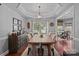 Dining room with a modern chandelier, rustic wood table, and neutral color scheme at 8700 Fox Tail Ln, Huntersville, NC 28078