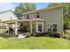 Rear exterior view featuring a covered patio and lush backyard at 8700 Fox Tail Ln, Huntersville, NC 28078