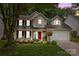 Charming two-story home with a red door, landscaped yard, and inviting front porch at 8700 Fox Tail Ln, Huntersville, NC 28078