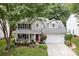 Two-story home with a well-maintained lawn and a charming red front door at 8700 Fox Tail Ln, Huntersville, NC 28078