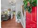 Bright foyer with a red door, hardwood floors, and view into the living room at 8700 Fox Tail Ln, Huntersville, NC 28078