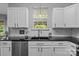 Bright kitchen with white cabinets, black countertop, subway tile backsplash and stainless steel dishwasher at 8700 Fox Tail Ln, Huntersville, NC 28078