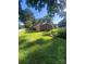 Large, grassy backyard featuring a garden bed, a partial view of the brick house, and a white picket fence at 903 Woodside Dr, Kings Mountain, NC 28086