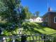 Expansive backyard with lush green lawn, garden area, shed, and charming white picket fence on a sunny day at 903 Woodside Dr, Kings Mountain, NC 28086