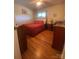 Well-lit bedroom with hardwood floors, red bedding, and traditional furnishings at 903 Woodside Dr, Kings Mountain, NC 28086