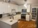 Well-lit kitchen with white cabinets, stainless steel appliances, quartz countertops, and hardwood floors at 903 Woodside Dr, Kings Mountain, NC 28086