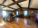 Charming living room featuring exposed beams, brick walls, wood floors, and a cozy wood-burning stove at 903 Woodside Dr, Kings Mountain, NC 28086