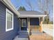 Inviting covered front porch with wood columns and railings on a blue house at 9930 Sardis Oaks Rd, Charlotte, NC 28270
