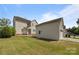 Large backyard featuring a detached garage, an exterior door, a home, and a grassy lawn at 10349 Alvarado Way, Charlotte, NC 28277