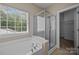 Bathroom featuring a soaking tub, separate shower, and natural light from large windows at 10349 Alvarado Way, Charlotte, NC 28277