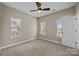 Neutral bedroom featuring carpet, a ceiling fan, a neutral paint scheme, and natural light from the three windows at 10349 Alvarado Way, Charlotte, NC 28277