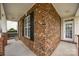 Inviting front porch with brick facade, dark shutters, a window, and white trim at 10349 Alvarado Way, Charlotte, NC 28277