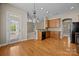 Open kitchen with wood cabinets, modern dishwasher, and hardwood flooring at 10349 Alvarado Way, Charlotte, NC 28277