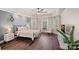 Bright bedroom boasts a tray ceiling, ample natural light, hardwood floors, and decorative sconces for a relaxing ambiance at 109 Walking Horse Trl, Davidson, NC 28036