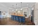 Open kitchen with large island, barstool seating, stainless appliances, and beautiful cabinetry at 109 Walking Horse Trl, Davidson, NC 28036