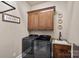 Well-equipped laundry room featuring front load washer and dryer, cabinets, and sink at 109 Walking Horse Trl, Davidson, NC 28036