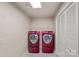 Efficient laundry room features modern red washer and dryer units, shelving, and storage options to keep things tidy at 109 Walking Horse Trl, Davidson, NC 28036